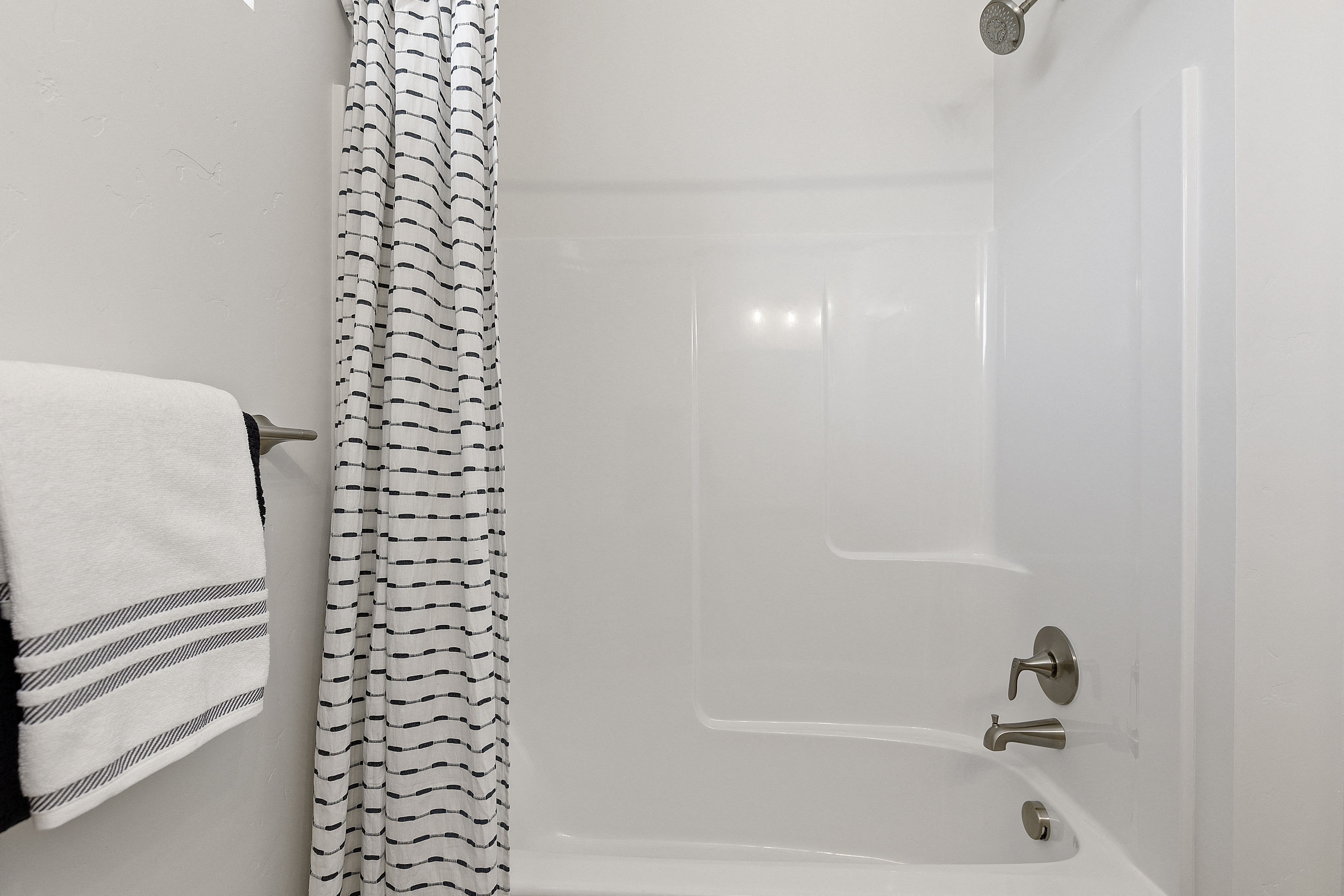 a bathroom with a white tub and shower and a black and white shower curtain at Alante Homes at Lake Hazel, Boise, Idaho